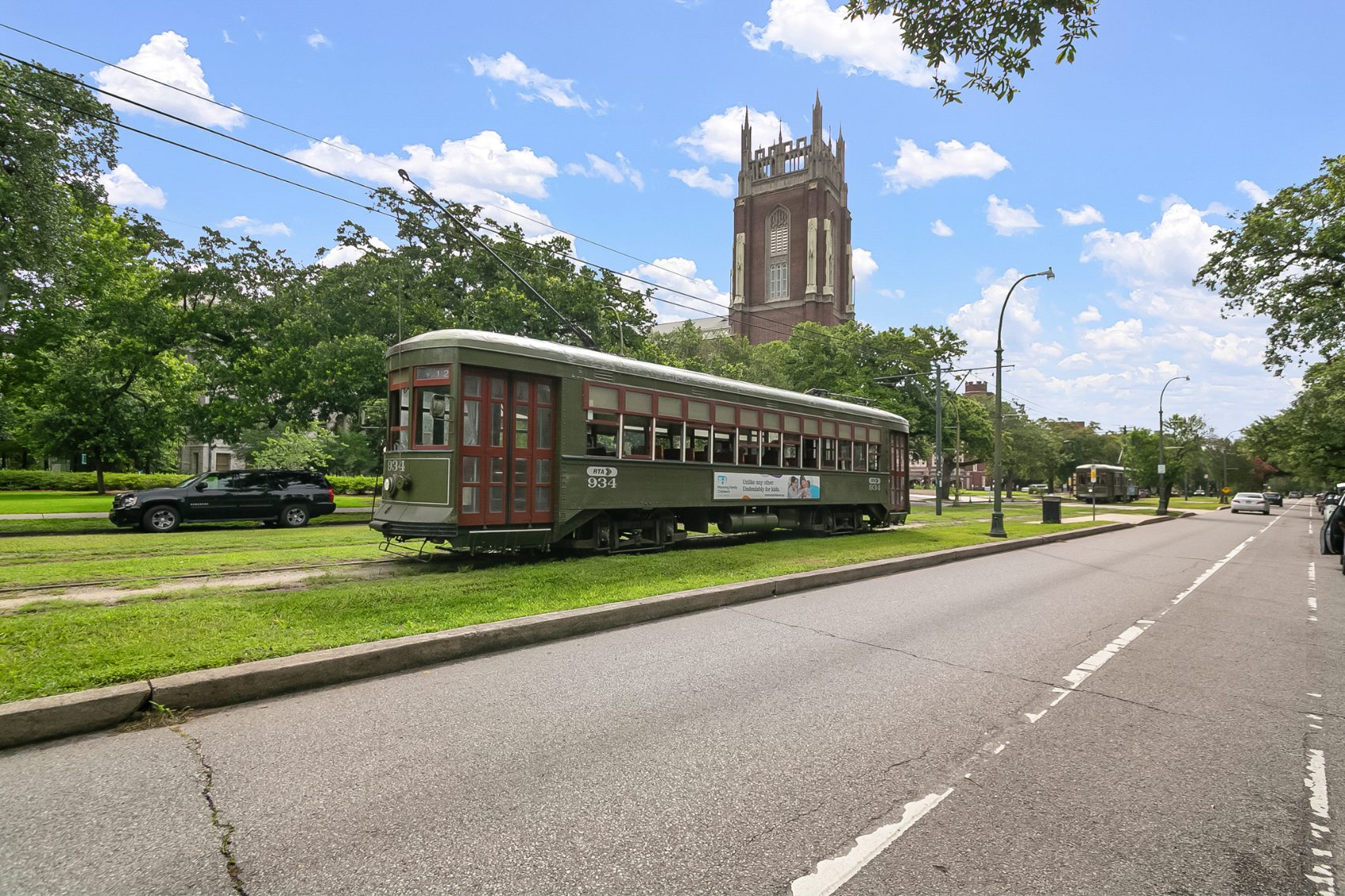 St. Charles Avenue streetcar passing a historic New Orleans church tower
